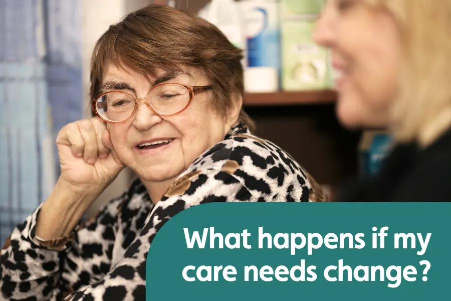 An older woman sat smiling while in conversation with her hand on her cheek. Another woman sits beside her, also smiling. The text overlay reads 'what happens if my care needs change'