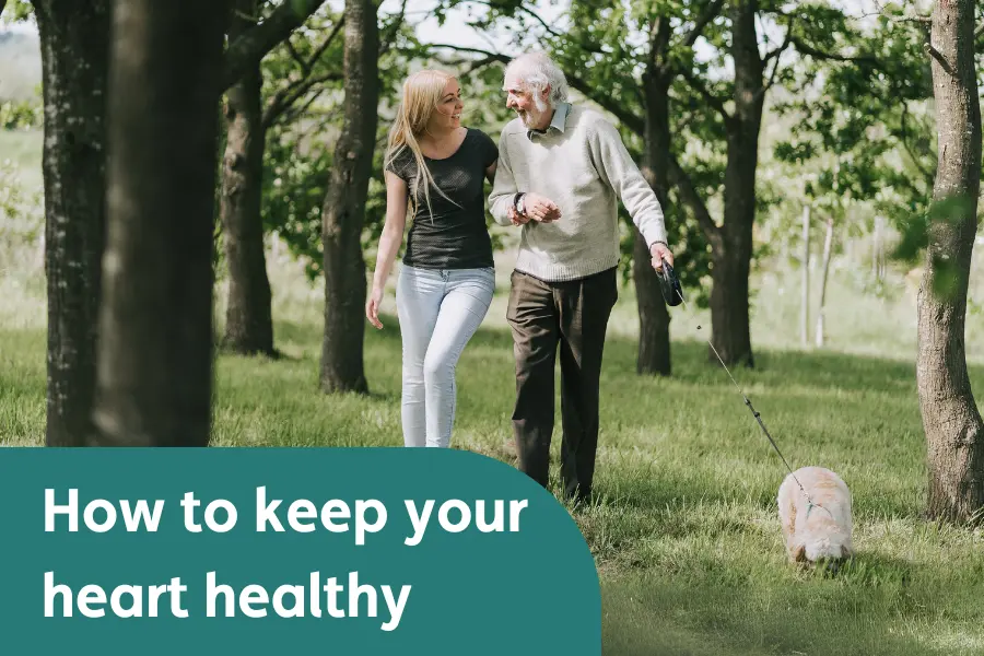 A man and his Caregiver walking a dog through some trees, overlayed with the text 'how to keep your heart healthy'