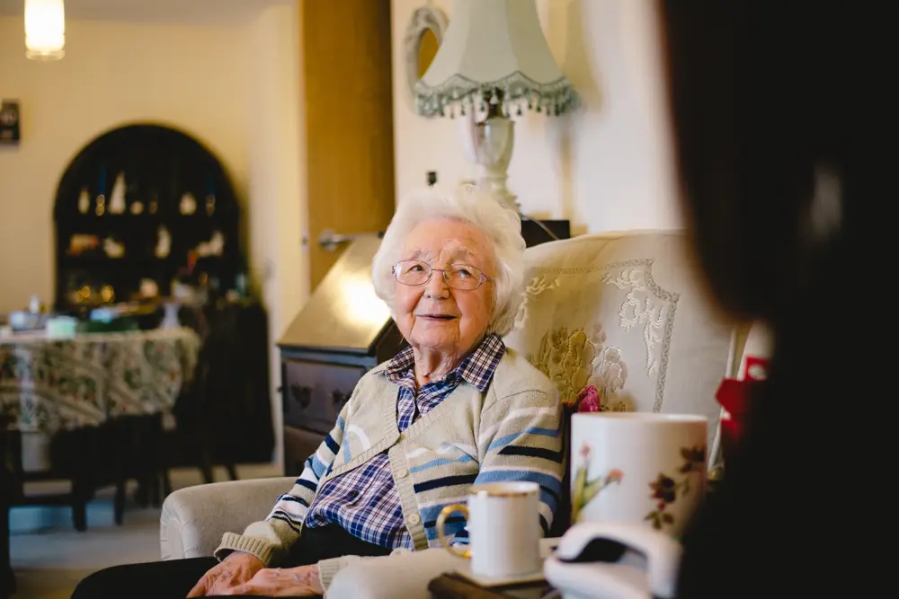lady sat in chair with cup of tea in foreground in the what is Dementia section of the page