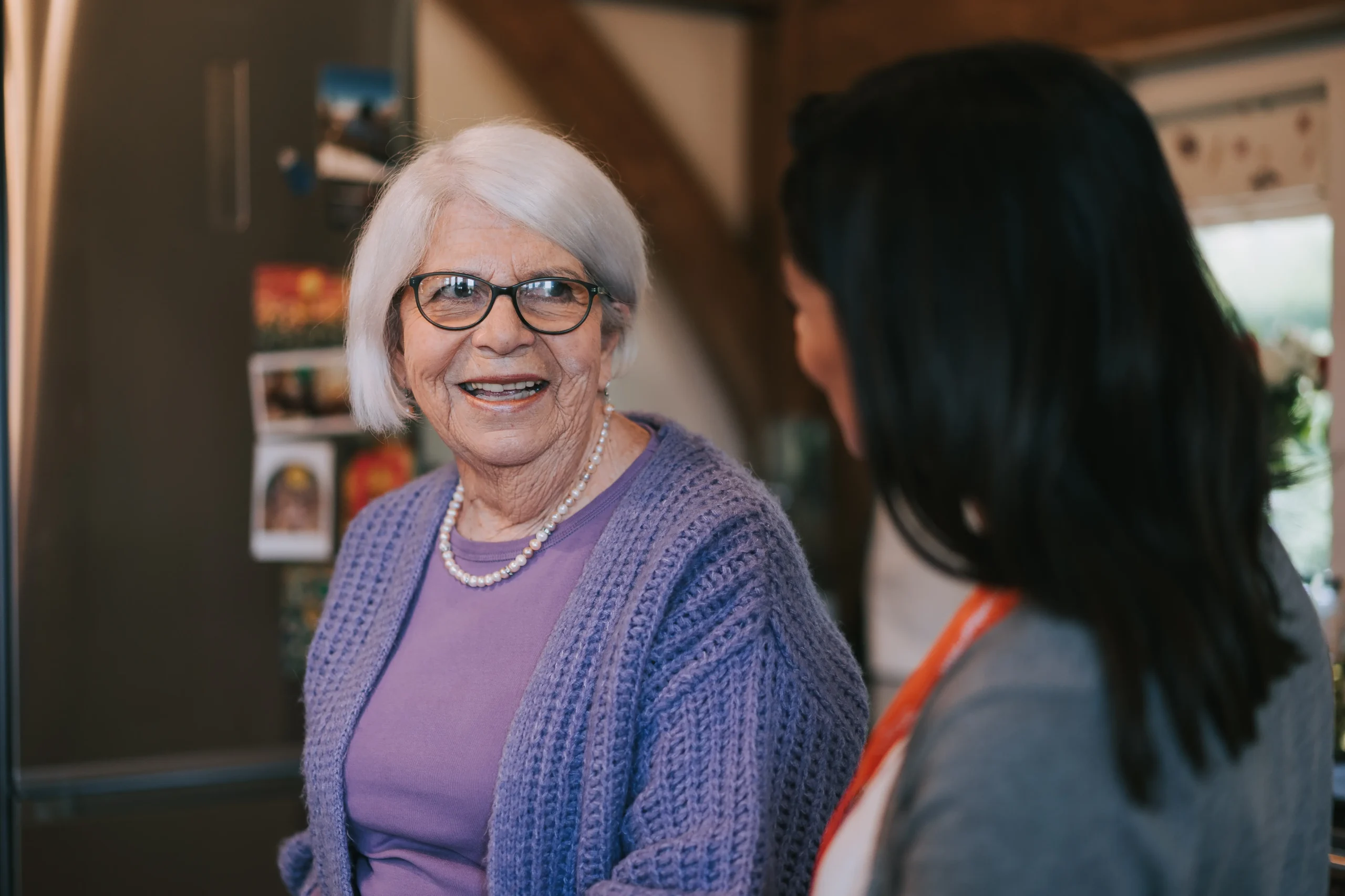 An elderly lady stood smiling at her Caregiver