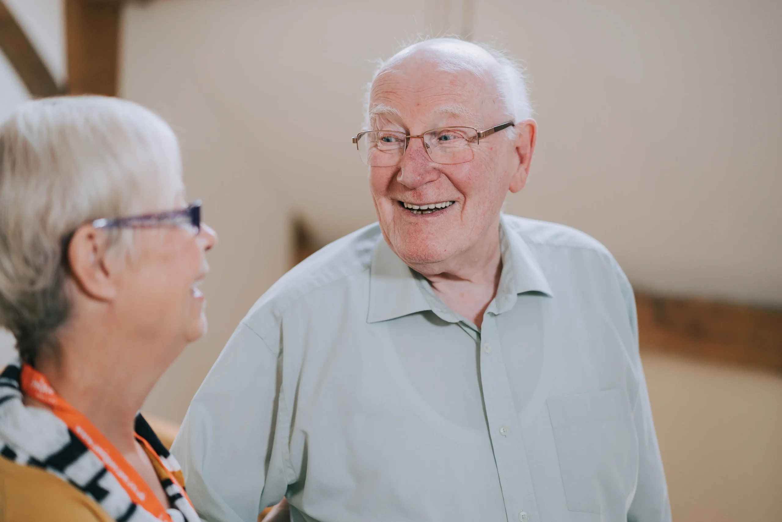 An elderly gentleman smiling warmly at his caregiver