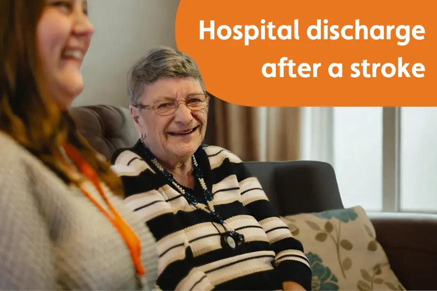 “An older woman smiling at home with a Caregiver beside her. Text reads: ‘Hospital discharge after a stroke.’”
