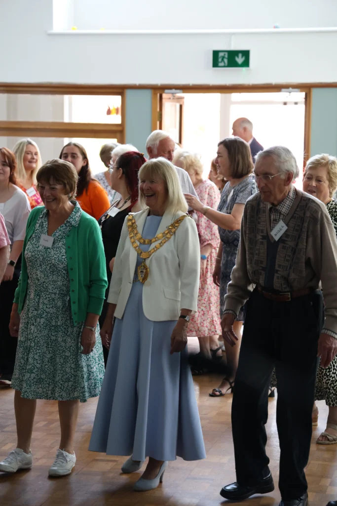 The Mayor of Solihull and guests smiling and joining in with dancing at the Memory Café celebration.