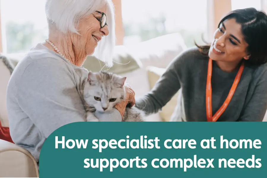 Featured image for blog on supporting complex needs at home. Image shows a lady and her carer sat on the sofa smiling while stroking at cat