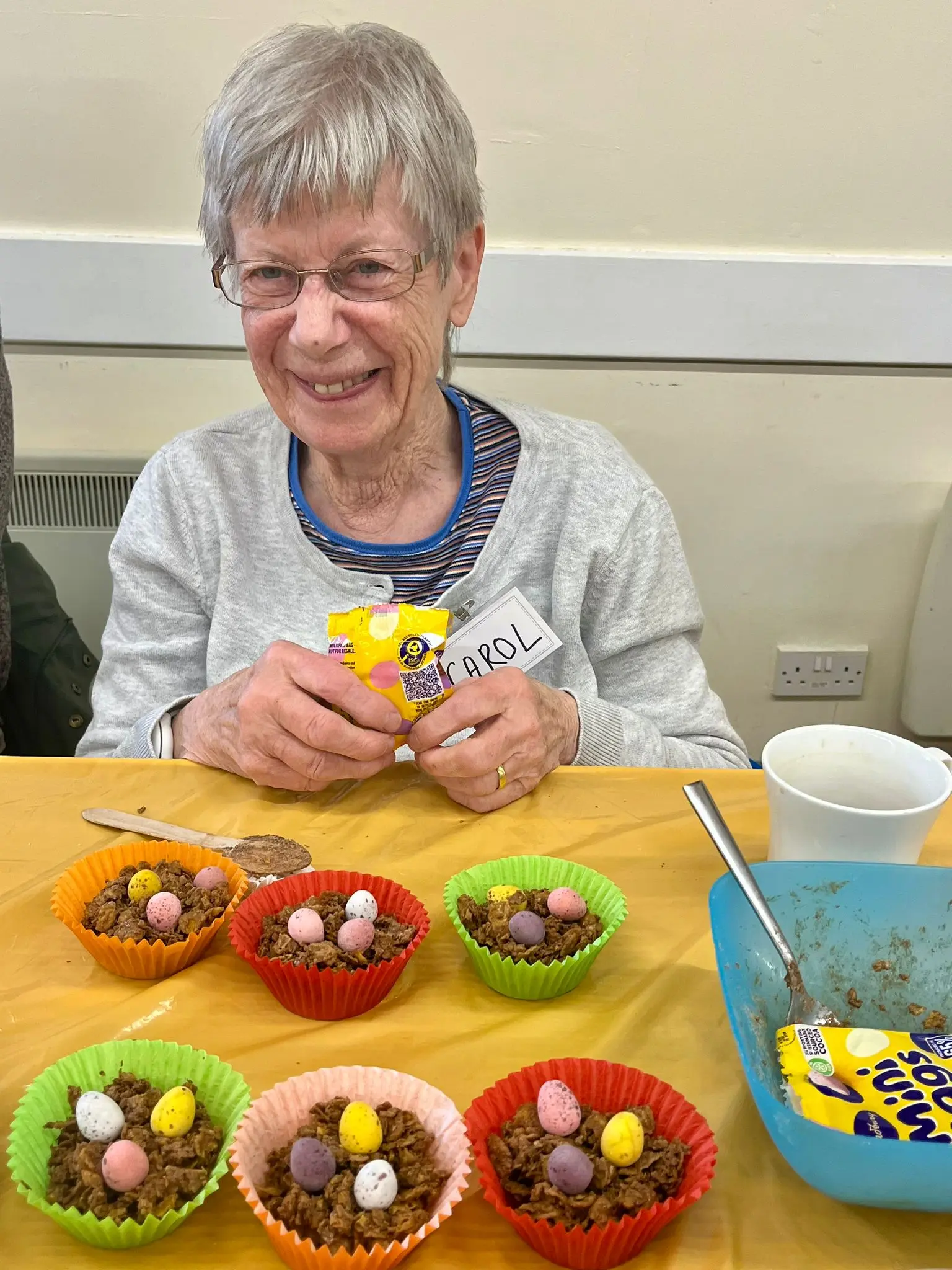 A lady at the Leamington memory cafe holding a cornflake cake, made as part of an activity