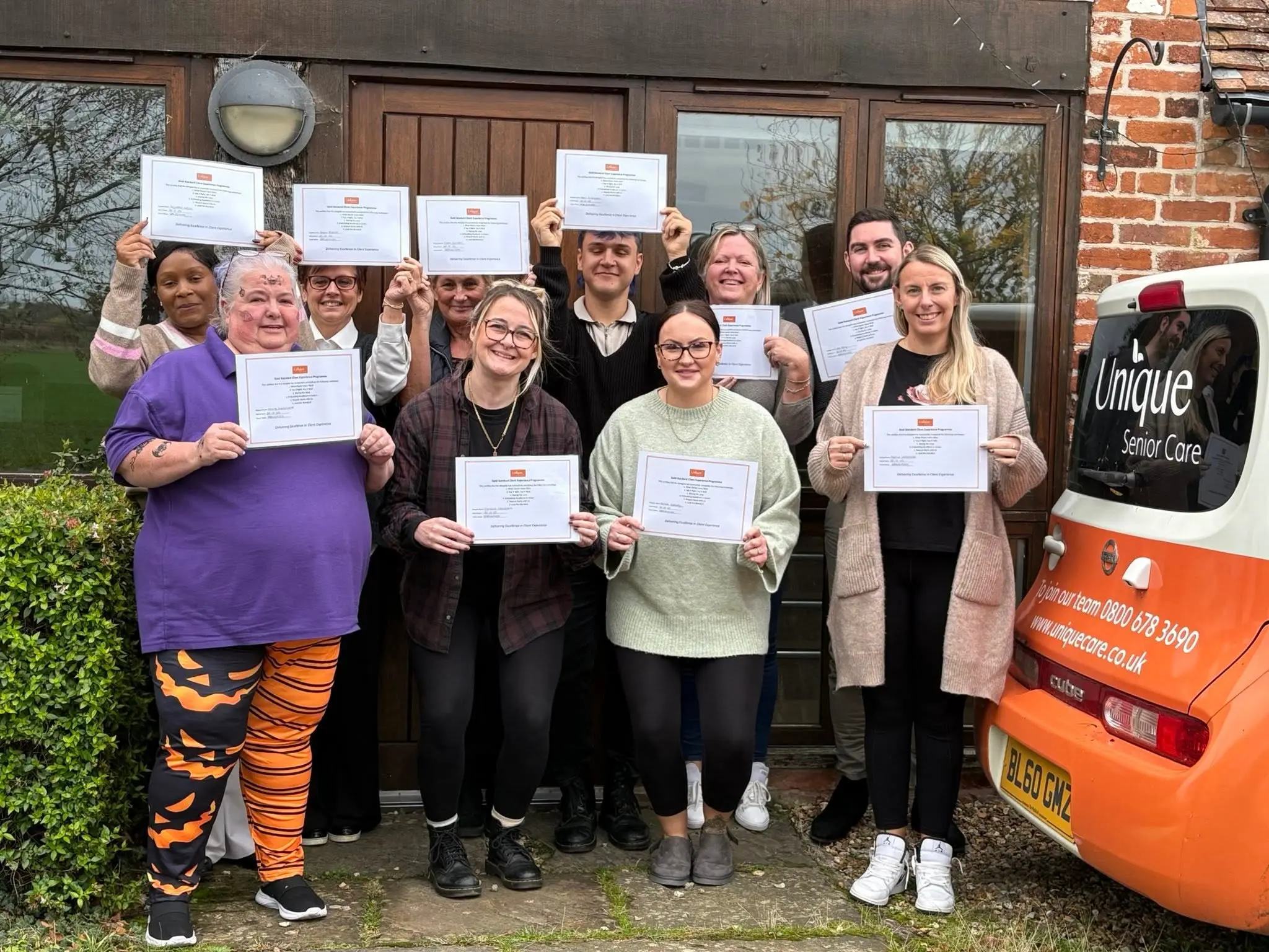 A group of managers holding certificates for completing a client experience programme