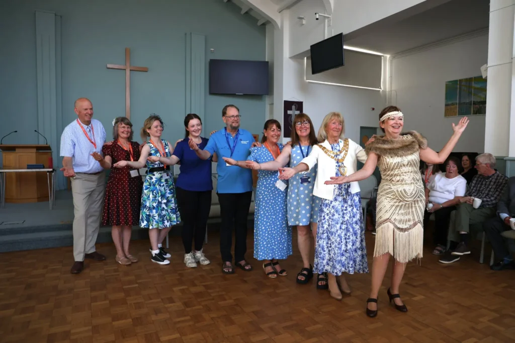 Organisers and volunteers of the knowle and dorridge memory cafe tea dance posing and smiling for the camera
