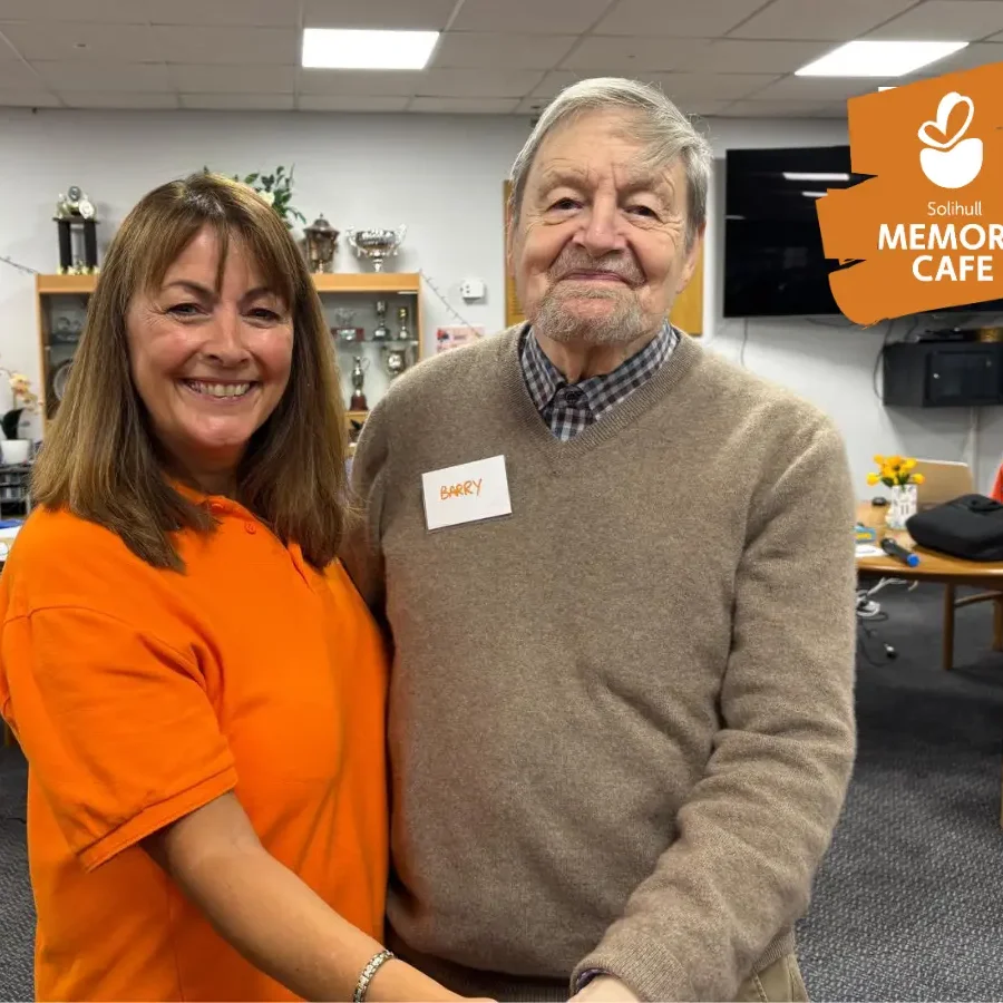 Coordinator Marian, with an attendee at the Solihull memory cafe, smiling at the camera